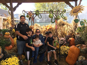 Family of 6 in a pumpkin patch: father, mother and 4 children