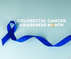Light blue background. A dark blue ribbon is at the front. The text in white to the right of the ribbon says, "Colorectal Cancer Awareness Month." Pathfinder compass replacing letter O in the word "Month."