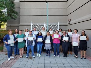 Image of a group of people holding certificates. People are in two rows.