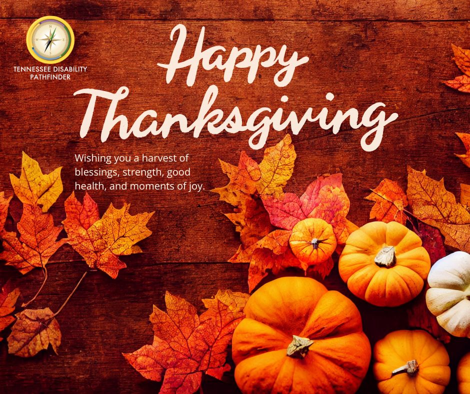 A festive Thanksgiving graphic featuring a wooden background decorated with orange and red autumn leaves and several small pumpkins in shades of orange and white. At the top, large cursive text reads “Happy Thanksgiving.” Below, smaller text says, “Wishing you a harvest of blessings, strength, good health, and moments of joy.” In the upper left corner, the Tennessee Disability Pathfinder logo with a compass icon is displayed.