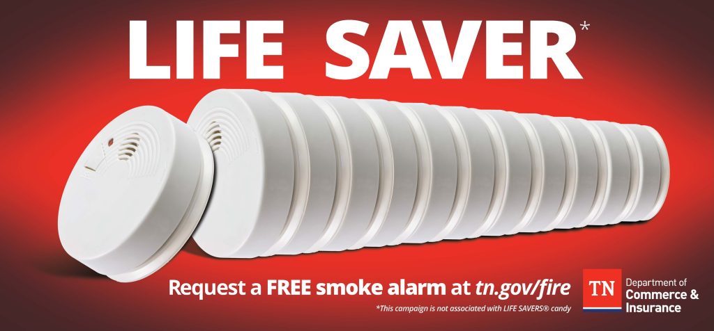 A graphic with a bright red background features a row of stacked smoke alarms stretching across the center. Large white text at the top reads “LIFE SAVER.” At the bottom, smaller text says “Request a FREE smoke alarm at tn.gov/fire.” The Tennessee Department of Commerce & Insurance logo appears on the right side.